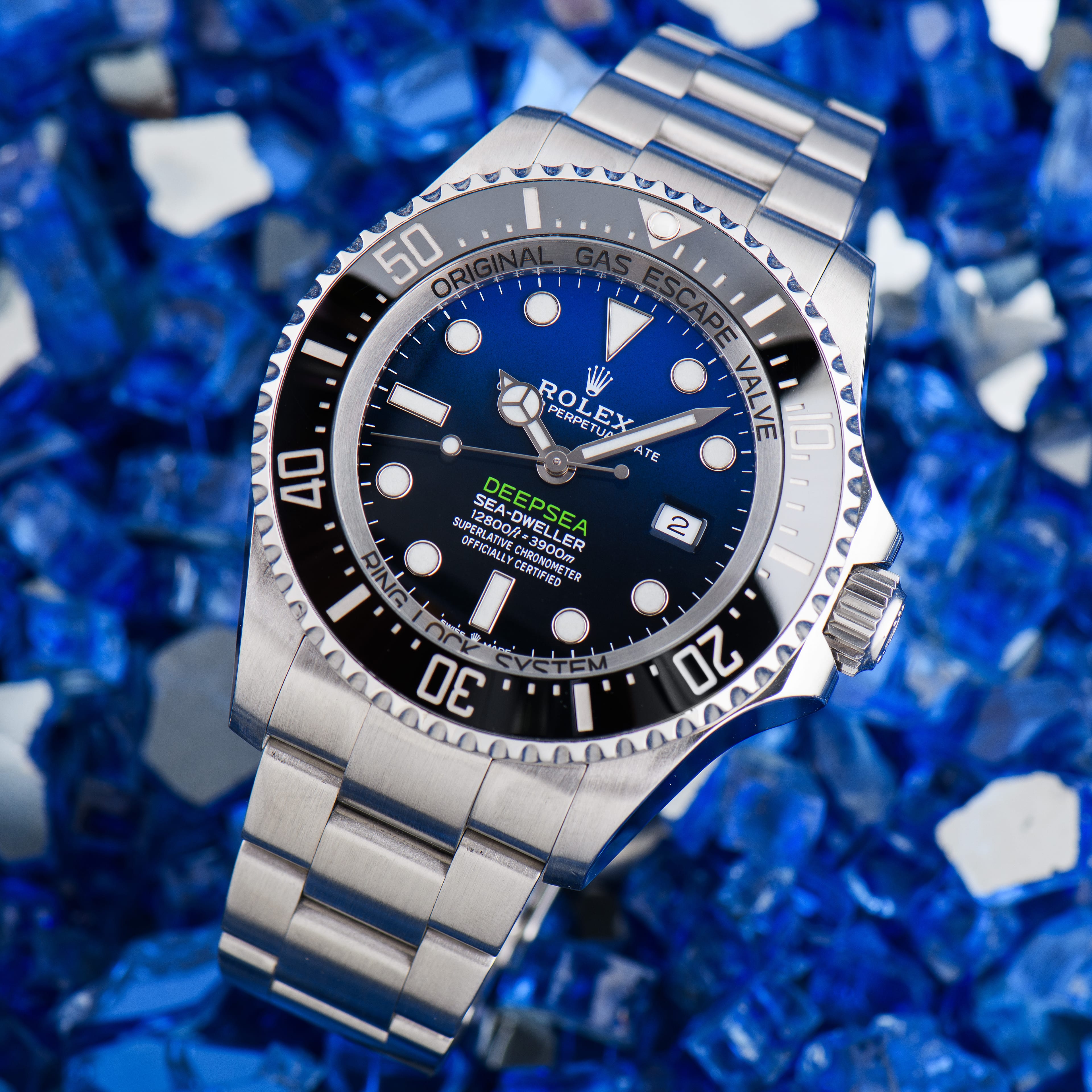A genuine Rolex Sea-Dweller Deepsea with a D-blue dial, shown dial-forward on a blue crushed-glass background